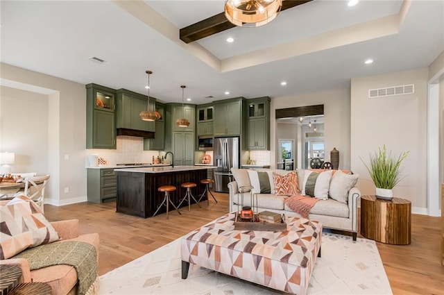 living area featuring recessed lighting, light wood-style floors, and visible vents