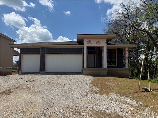 18452 Pawnee Ln, Overland Park, KS 66085 - view of front of home with a garage, driveway, and a porch