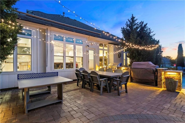 patio terrace at dusk featuring outdoor dining area and area for grilling