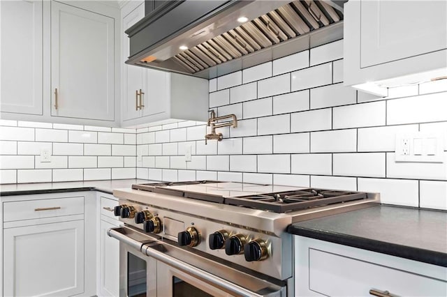 kitchen featuring dark countertops, custom exhaust hood, range with two ovens, and backsplash