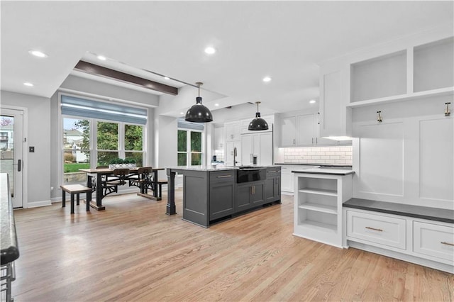 kitchen with paneled built in refrigerator, white cabinetry, and open shelves