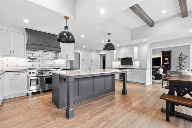 kitchen featuring range with two ovens, light wood-type flooring, backsplash, and wine cooler