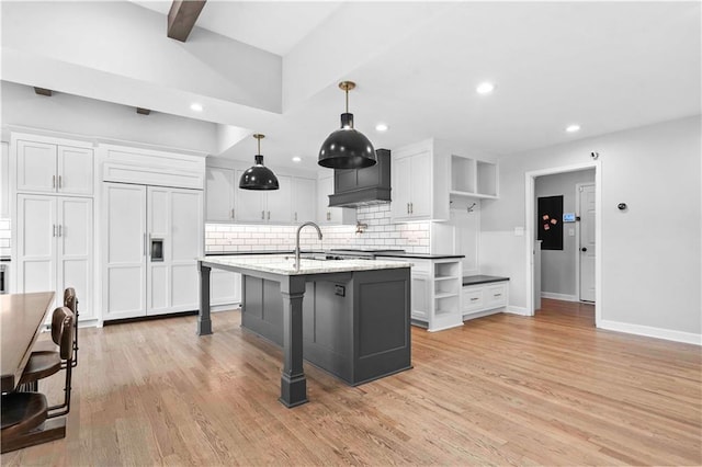 kitchen with open shelves, light wood-type flooring, white cabinetry, and custom range hood