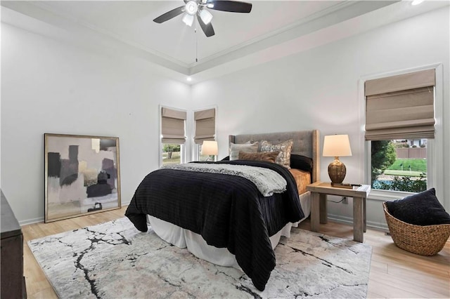 bedroom with ceiling fan, wood finished floors, and baseboards