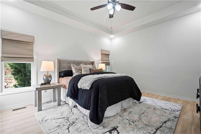 bedroom featuring baseboards, visible vents, ceiling fan, and wood finished floors