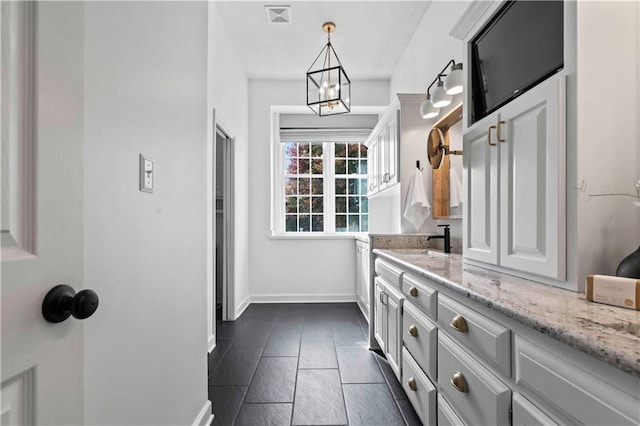 bathroom featuring a chandelier, visible vents, vanity, and baseboards