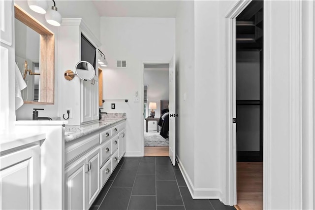 ensuite bathroom featuring double vanity, visible vents, baseboards, ensuite bath, and tile patterned floors