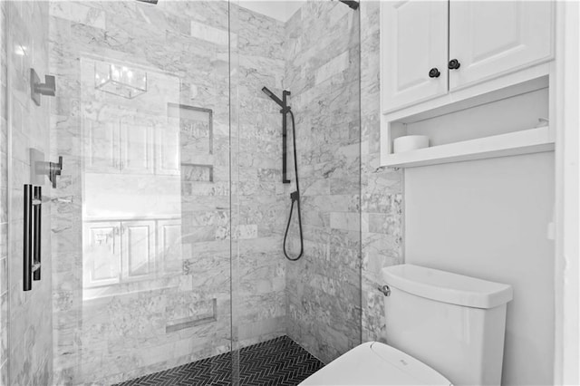 full bath featuring toilet and a marble finish shower