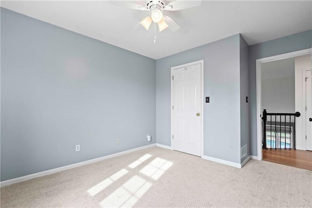 unfurnished bedroom with a ceiling fan, carpet flooring, visible vents, and baseboards