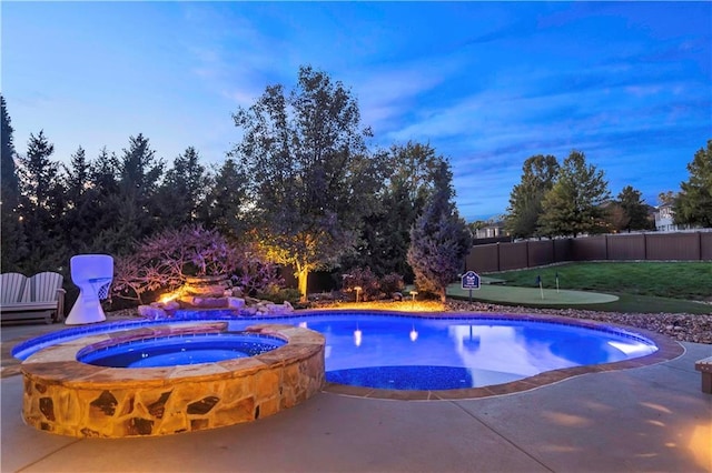 view of swimming pool featuring a pool with connected hot tub, fence, and a patio