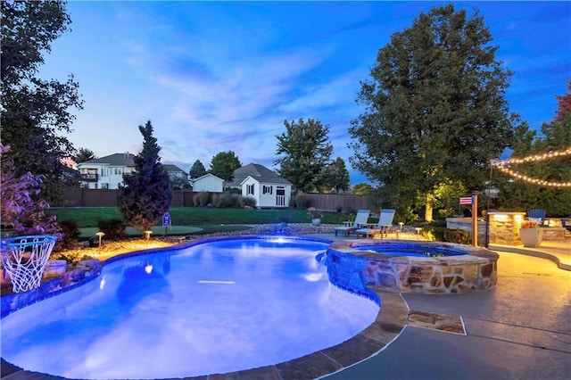 view of pool featuring an outbuilding, a patio, fence, and a pool with connected hot tub