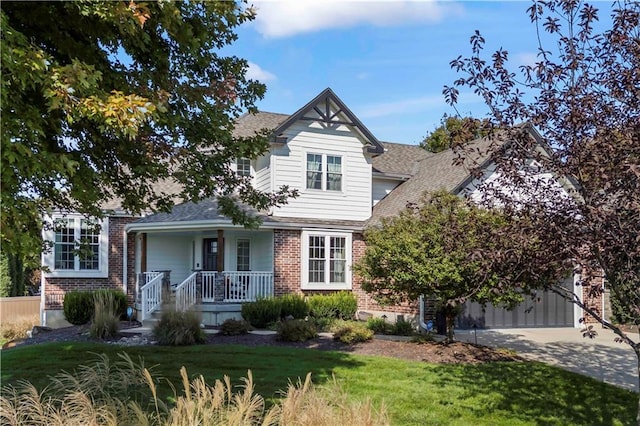 view of front of house featuring concrete driveway, an attached garage, covered porch, a front lawn, and brick siding