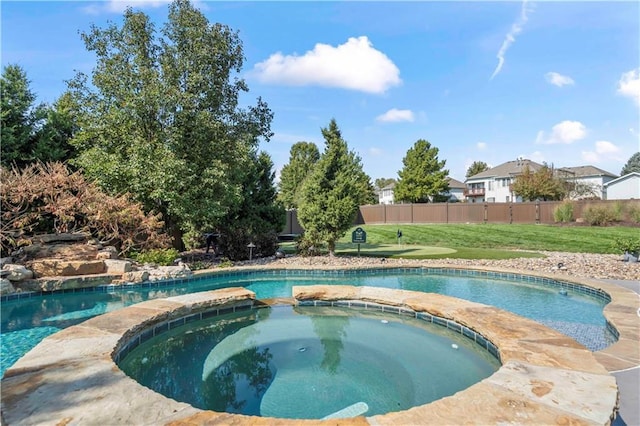 view of swimming pool with a pool with connected hot tub, fence, and a yard