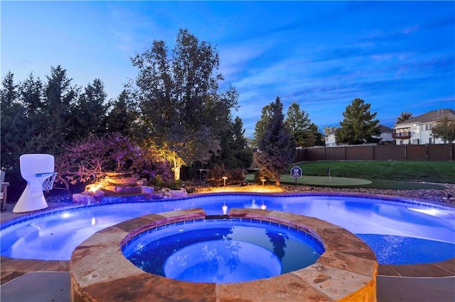 view of pool featuring a pool with connected hot tub and fence