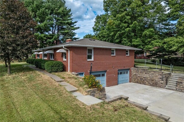 view of side of home featuring a garage and a yard