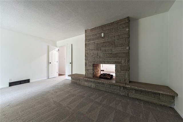 unfurnished living room with a textured ceiling, a fireplace, and carpet flooring