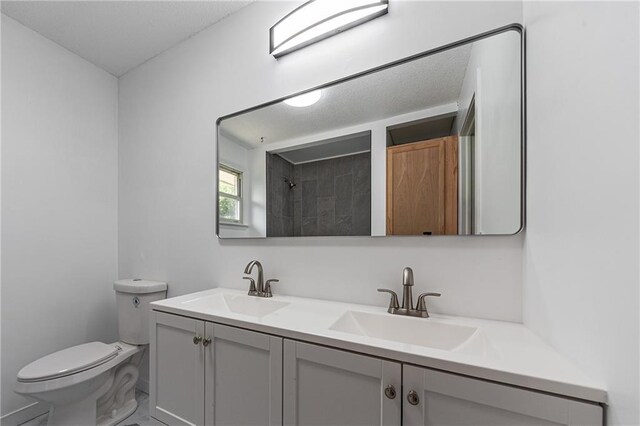 bathroom featuring walk in shower, vanity, and toilet