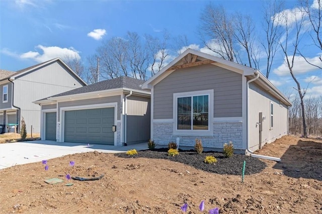 view of front of home featuring stone siding, driveway, and an attached garage