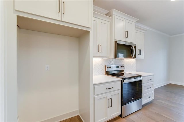 kitchen featuring tasteful backsplash, baseboards, light wood-style flooring, stainless steel appliances, and light countertops