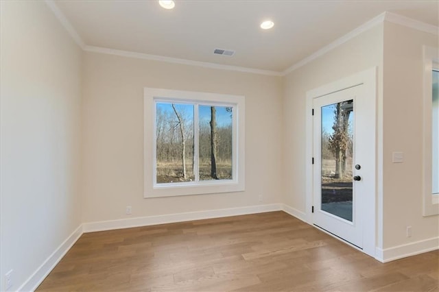 spare room featuring recessed lighting, wood finished floors, visible vents, baseboards, and crown molding