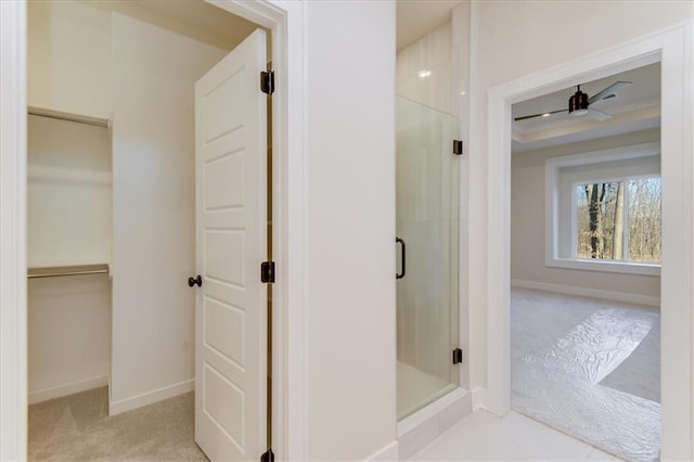 full bath with a shower stall, baseboards, and a spacious closet