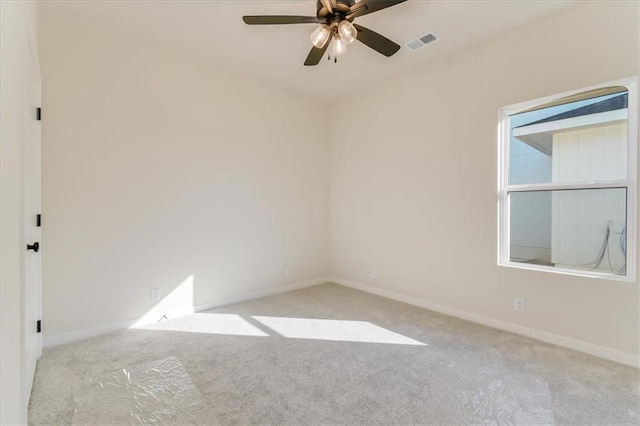 empty room featuring baseboards, carpet flooring, visible vents, and a ceiling fan