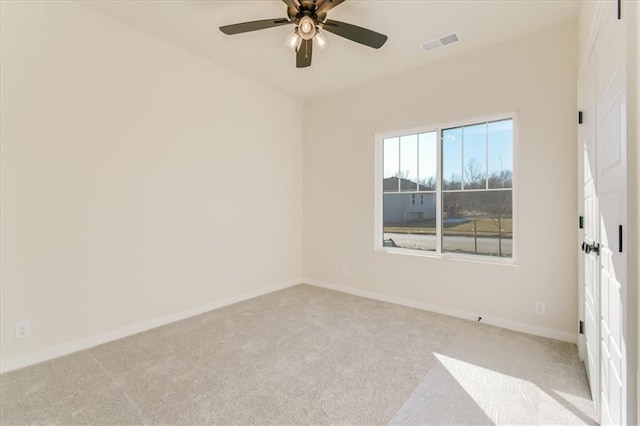 spare room with carpet floors, visible vents, baseboards, and a ceiling fan