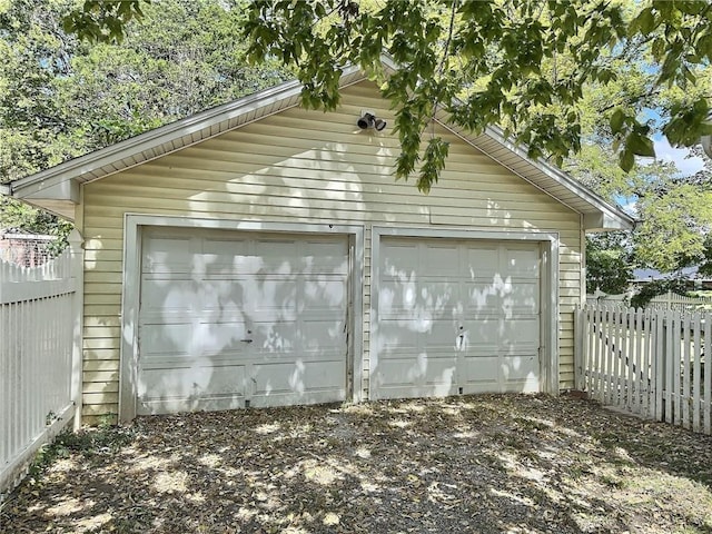 detached garage featuring fence