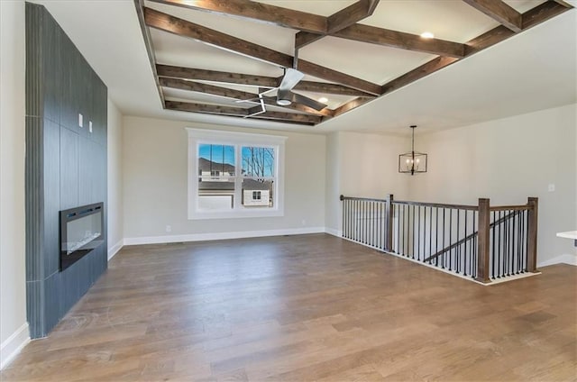 unfurnished living room featuring baseboards, a fireplace, heating unit, and wood finished floors