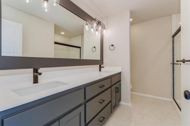 bathroom featuring a sink, a shower stall, baseboards, and double vanity