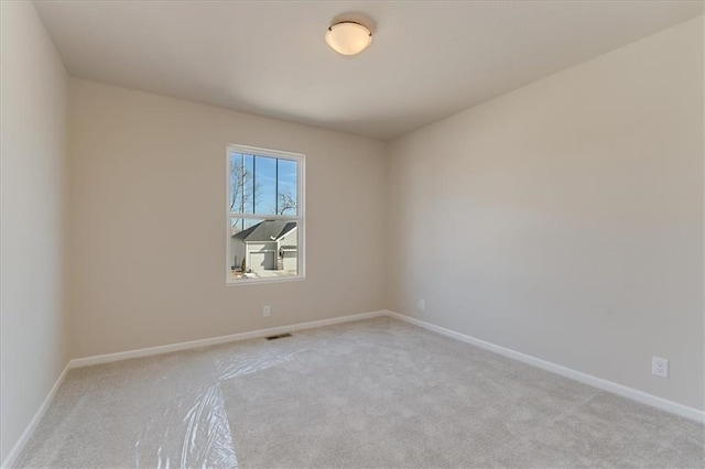 empty room with visible vents, baseboards, and carpet flooring