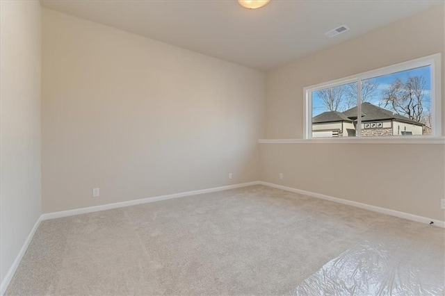 carpeted empty room featuring visible vents and baseboards