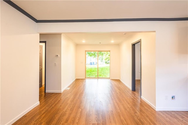 unfurnished room with wood-type flooring and ornamental molding