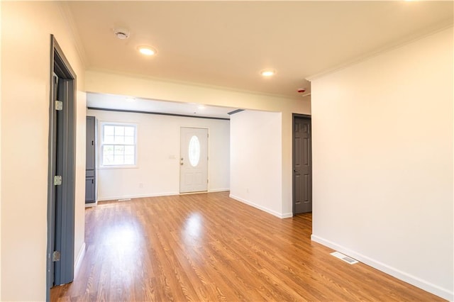 foyer with light hardwood / wood-style floors and crown molding