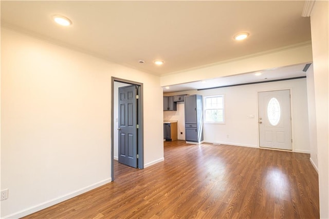 entrance foyer with dark hardwood / wood-style floors and crown molding