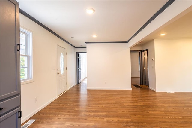 foyer featuring wood-type flooring and ornamental molding