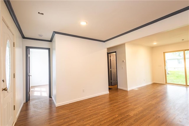 empty room featuring wood-type flooring and crown molding