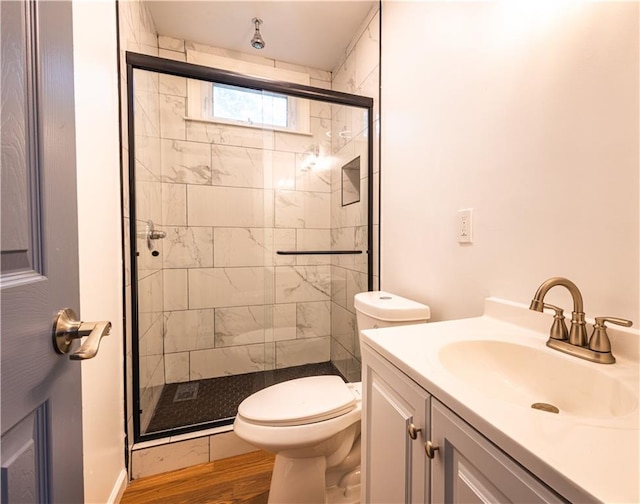 bathroom with vanity, an enclosed shower, hardwood / wood-style floors, and toilet