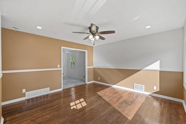 spare room with ceiling fan, a textured ceiling, and dark hardwood / wood-style floors