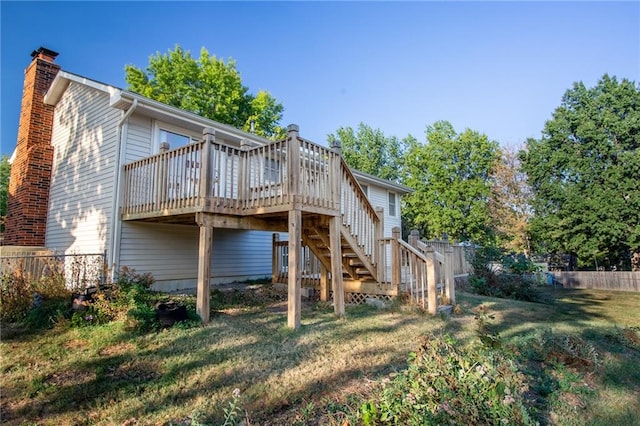 rear view of property with a yard and a wooden deck