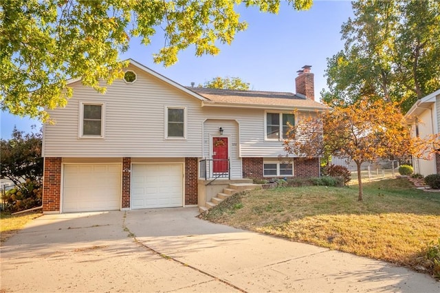 split foyer home featuring a garage and a front yard