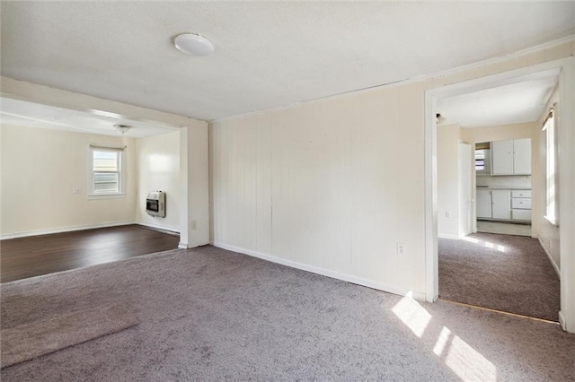 carpeted spare room featuring heating unit