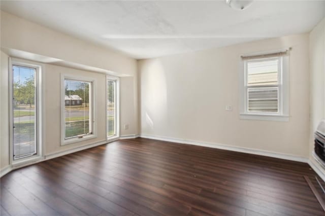 unfurnished room with dark hardwood / wood-style flooring