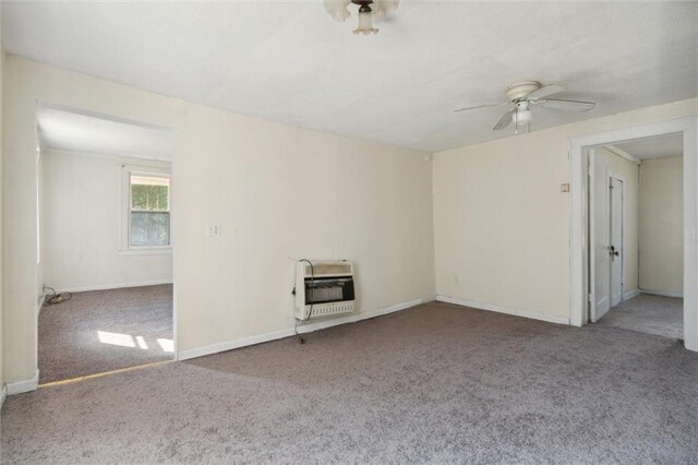 empty room with ceiling fan, light colored carpet, and heating unit