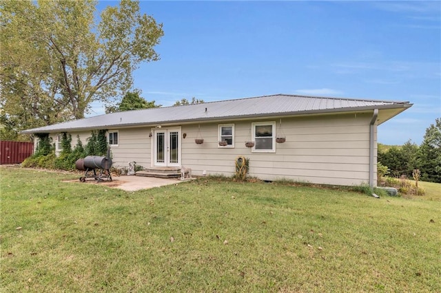 back of house with a lawn, a patio area, and french doors