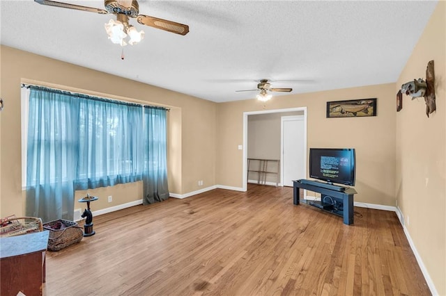 living room with a textured ceiling, hardwood / wood-style floors, and ceiling fan