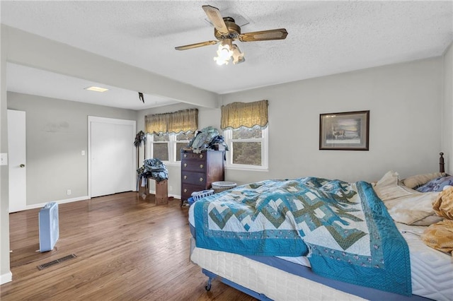 bedroom featuring a textured ceiling, ceiling fan, and hardwood / wood-style flooring