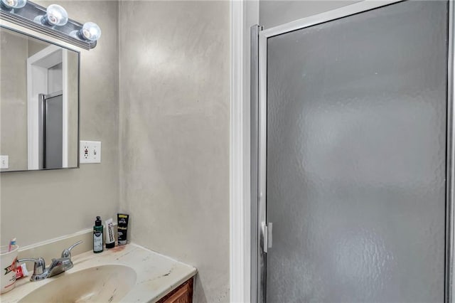 bathroom featuring walk in shower and vanity