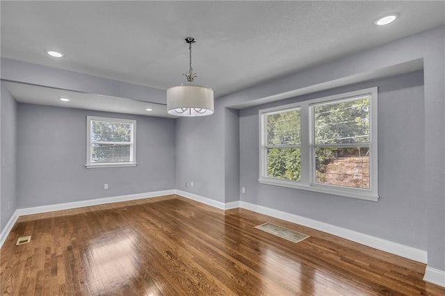 unfurnished room with wood-type flooring and a healthy amount of sunlight