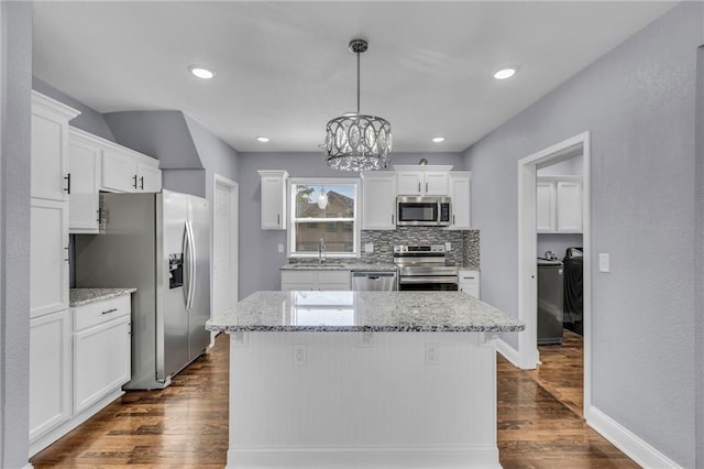 kitchen featuring white cabinets, stainless steel appliances, dark hardwood / wood-style floors, and a center island